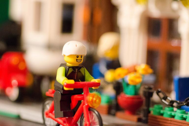 Lego figure riding a bicycle.