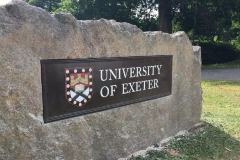 Granite boulder with University of Exeter sign and coat of arms