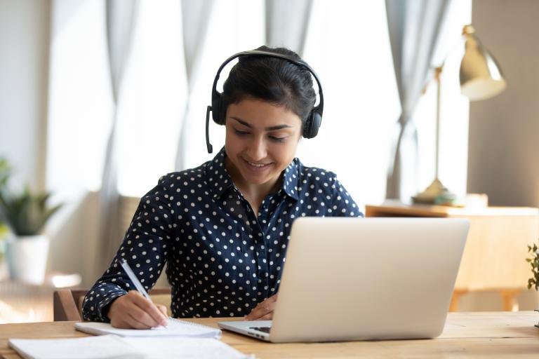 Student working on laptop wearing a headset