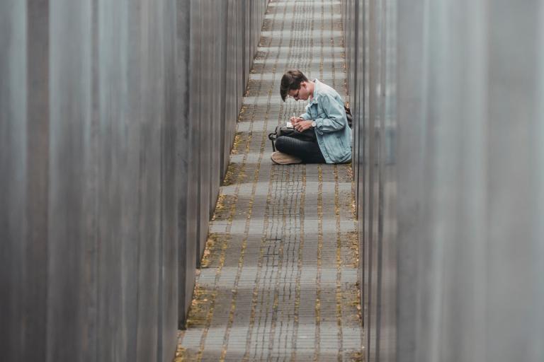 Student sitting cross-legged in a corridor