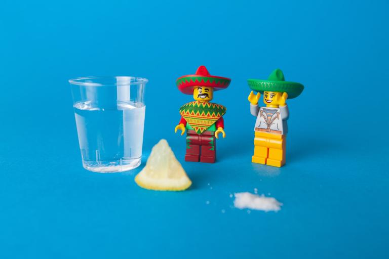 Two Lego figures in sombreros with lemon and tequila.