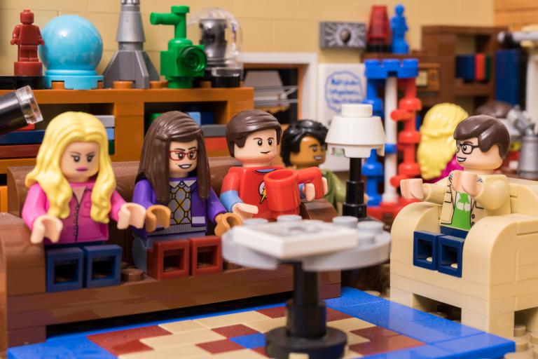 Lego people sitting talking in a Lego room.