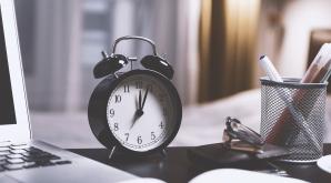 alarm clock, laptop, notebook and pens